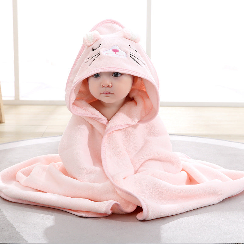 Baby wrapped in a pink hooded bath towel with a cute bunny face and ears, sitting comfortably and looking adorable.
