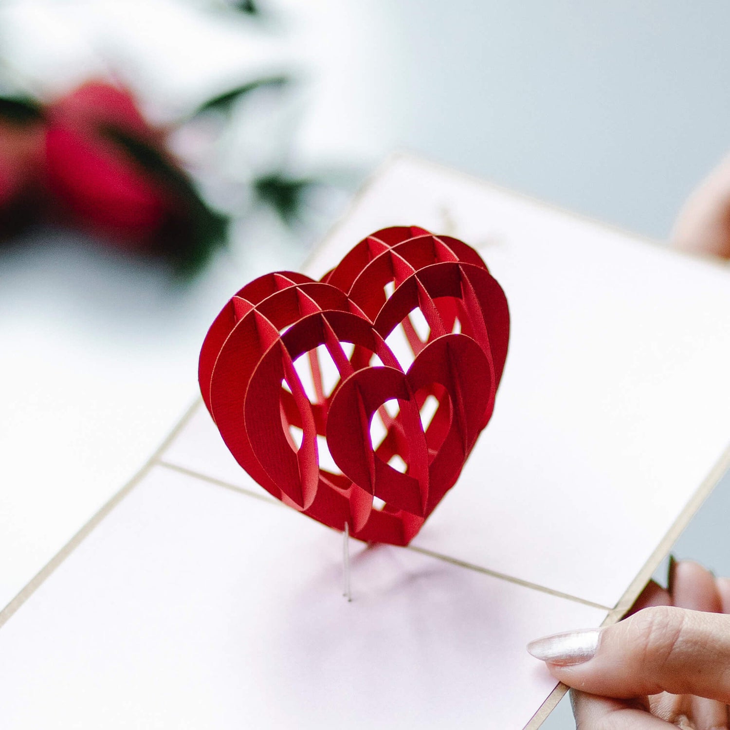A pop up paper heart shape on an open gift card.