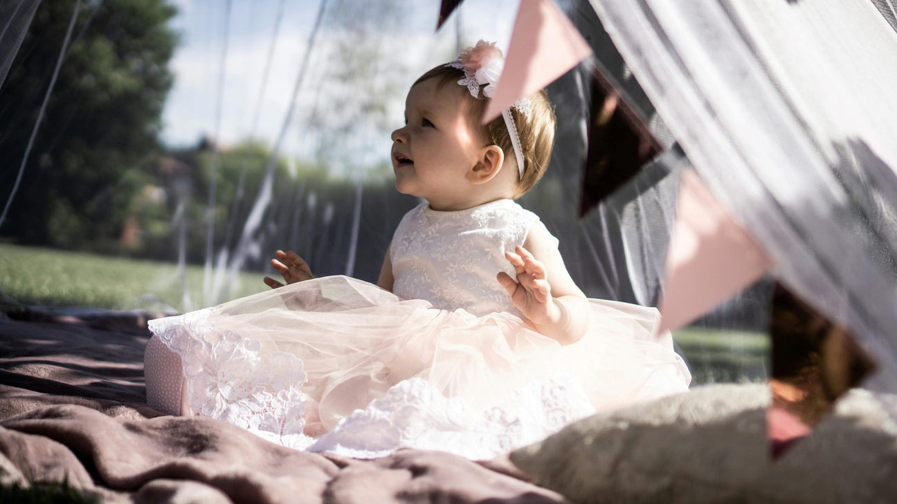 a baby girl happily looking at her gifts