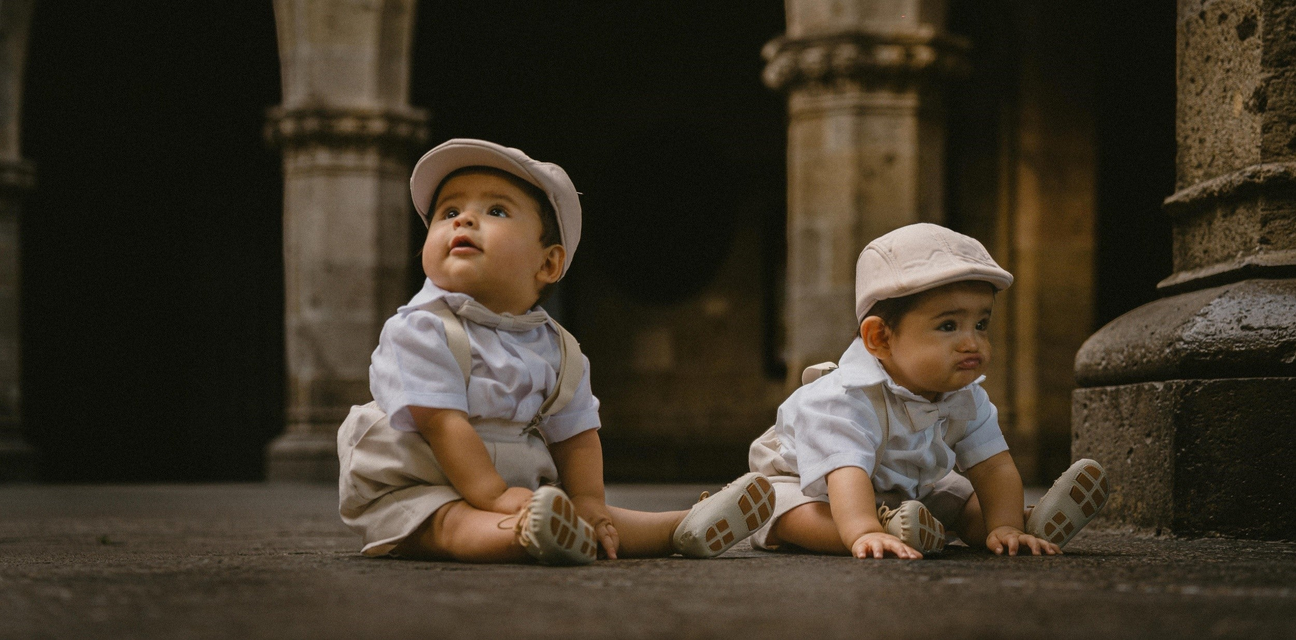 a twin baby boys are happily waiting for their gifts