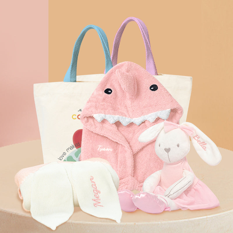Baby Hamper - Pink Shark Adventure Gift Set: Pink Shark bathrobe, pink ballet bunny plushie, pink knit bunny blanket with embroidered name, and Cadeaus brand canvas bag packaging.