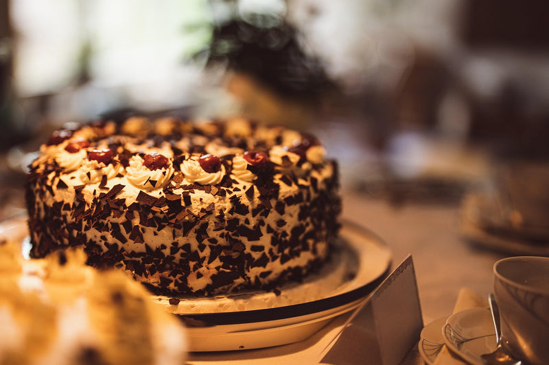 Chocolate cake with white frosting on a table with a blurred background