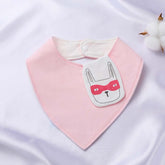 Pink organic cotton baby bib with an embroidered bunny face wearing a red mask, featuring a snap closure for easy use.