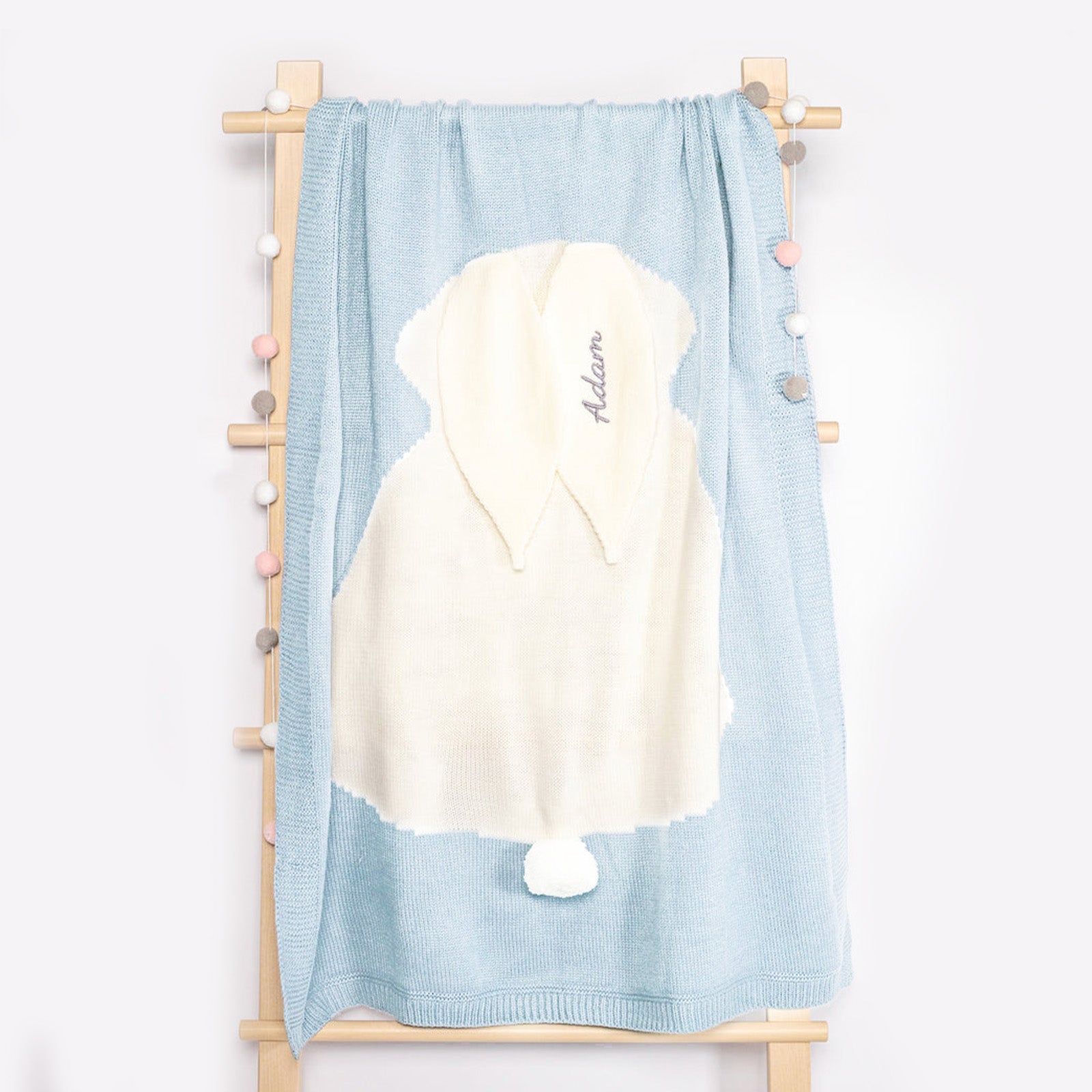 Baby Blue Bunny Knit blanket hanging on rack with baby&
