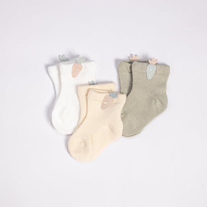 Three pairs of socks with carrot patterns on a white background. The socks are from left to right: orange, green, and blue.