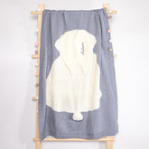 Elegant baby blanket hung on a wooden ladder, showcasing a dual-tone design with a cozy white bunny shape on a gray background. The bunny&