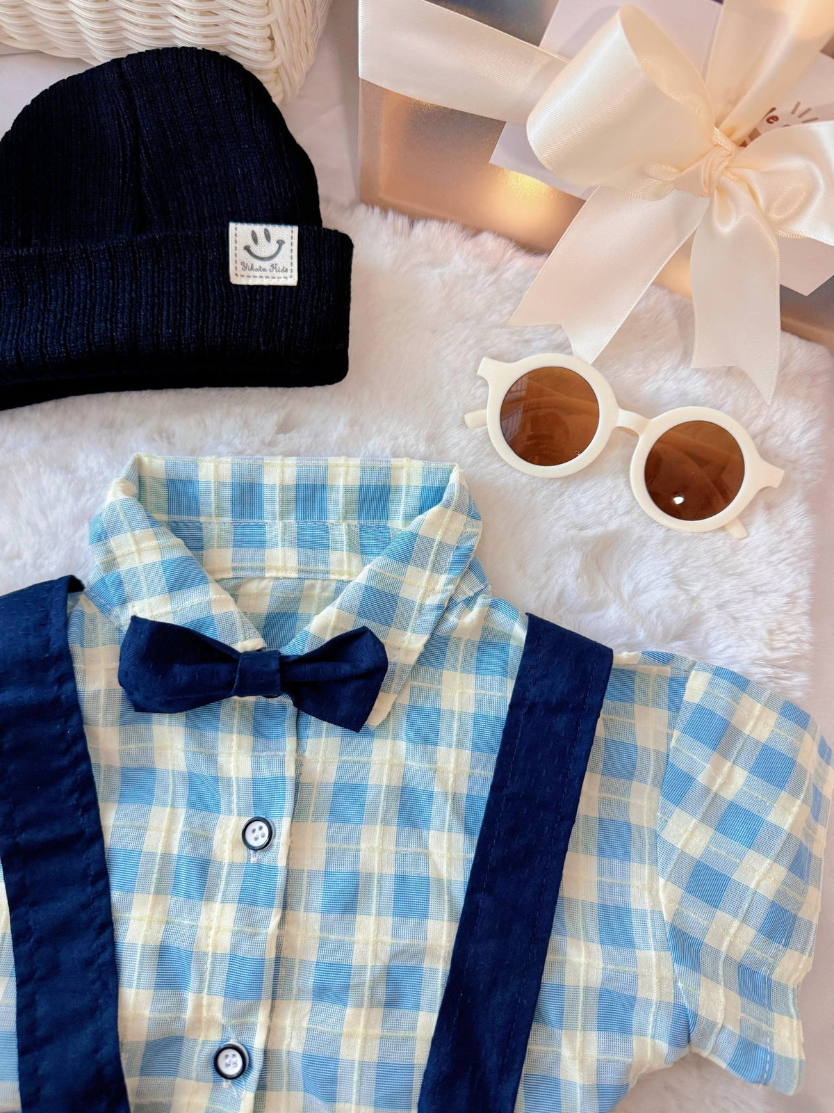 Charlie Boy baby outfit flat lay – blue gingham shirt with bow tie and suspender shorts