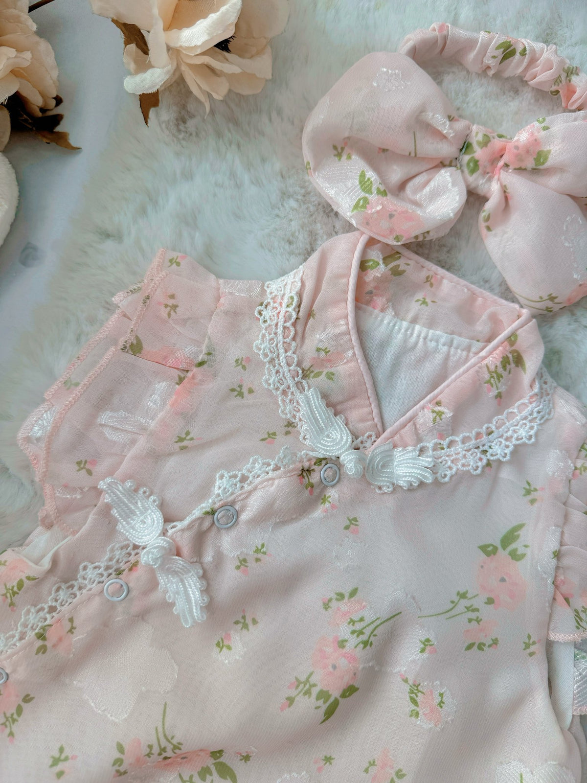 Cherry Blossom baby outfit flat lay – pink floral cheongsam-style romper with bow headband