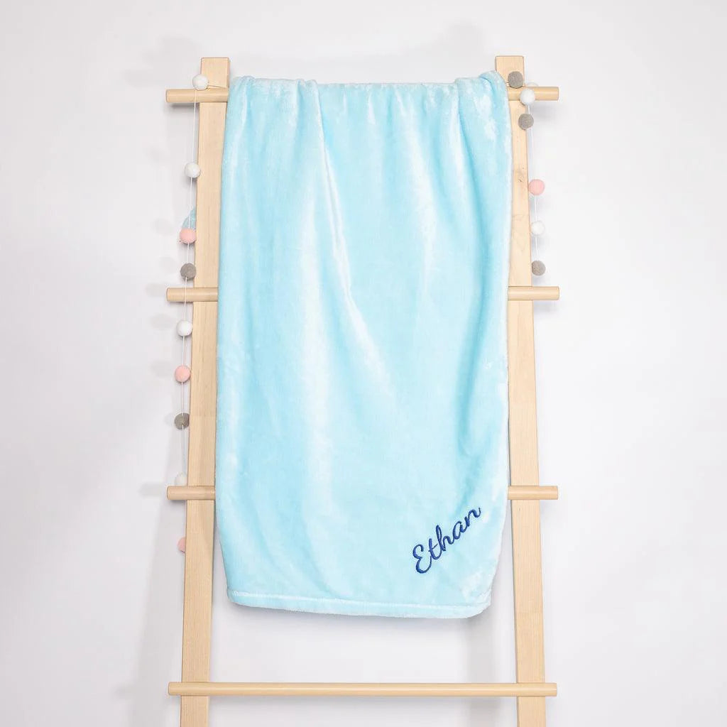 Light blue fleece blanket with ‘Chris’ embroidered on it.