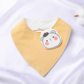 Yellow organic cotton baby bib with an embroidered bear face, featuring a snap closure for easy use.