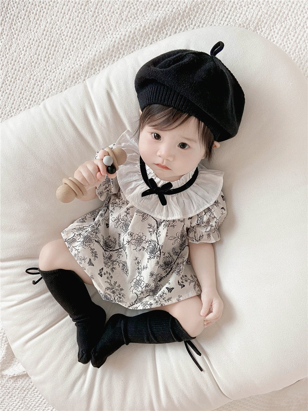 Baby wearing the French Blossom floral romper with ruffled collar and black beret