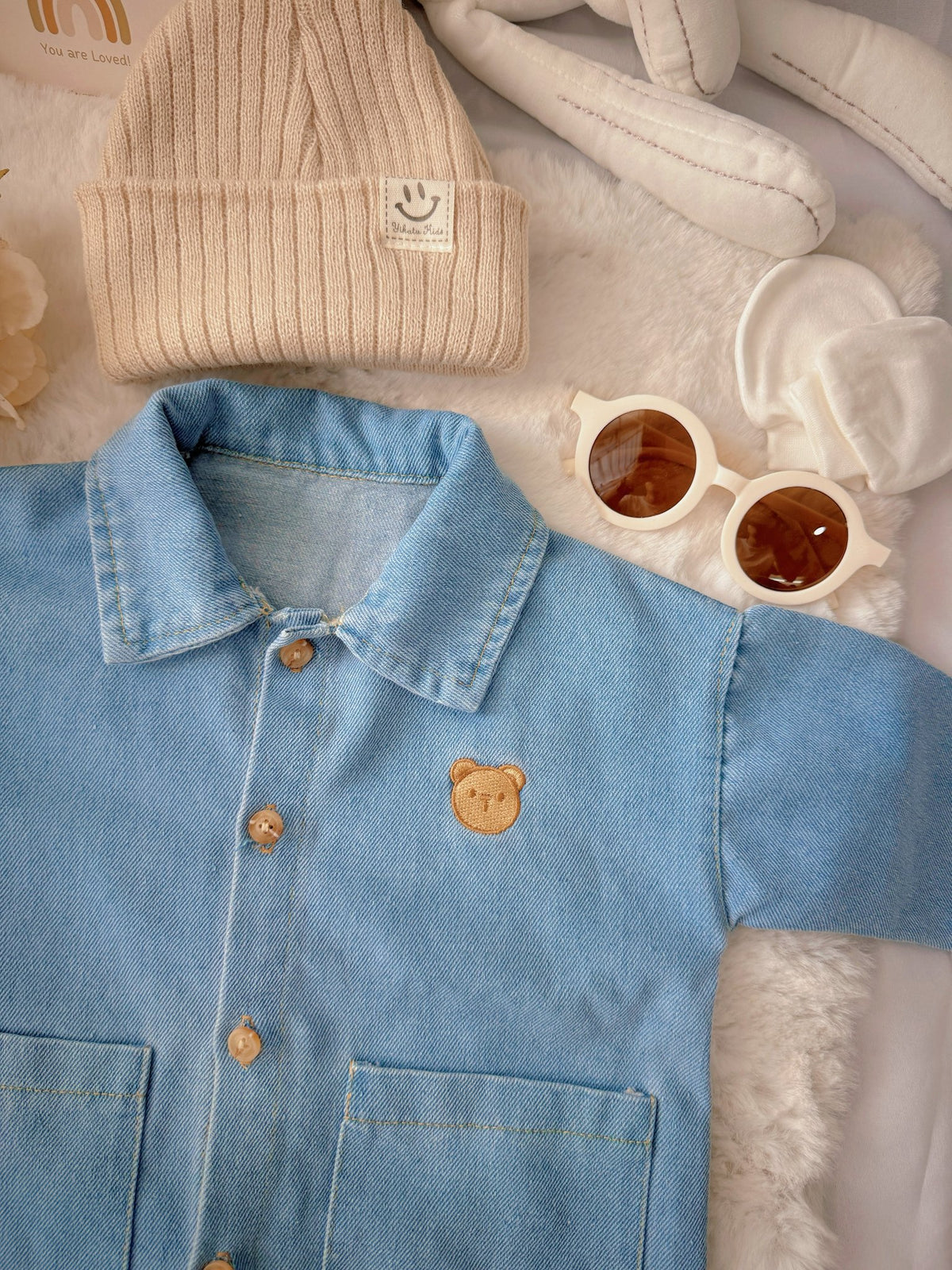 Little Denim Bear baby outfit flat lay – denim romper with bear badge and knit beanie