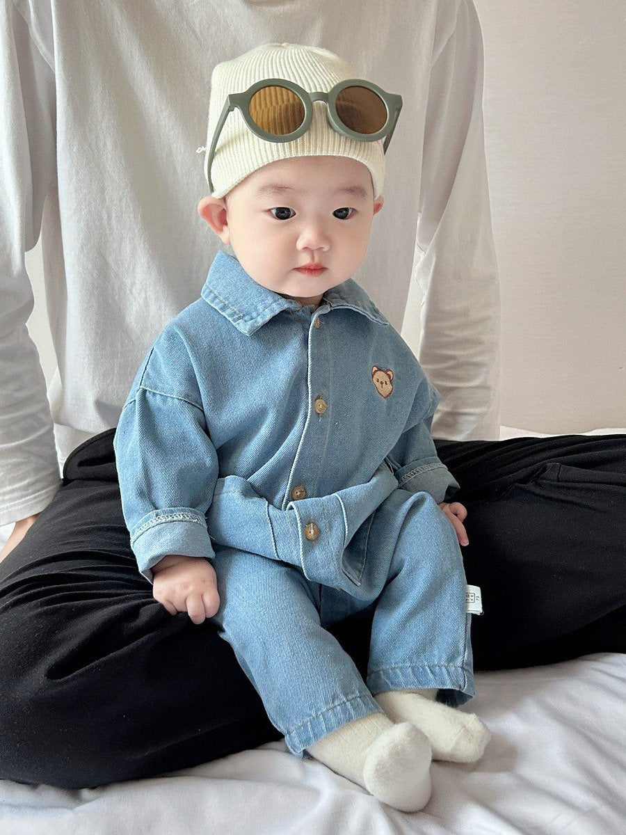 Baby wearing the Little Denim Bear denim romper with bear badge and knit beanie