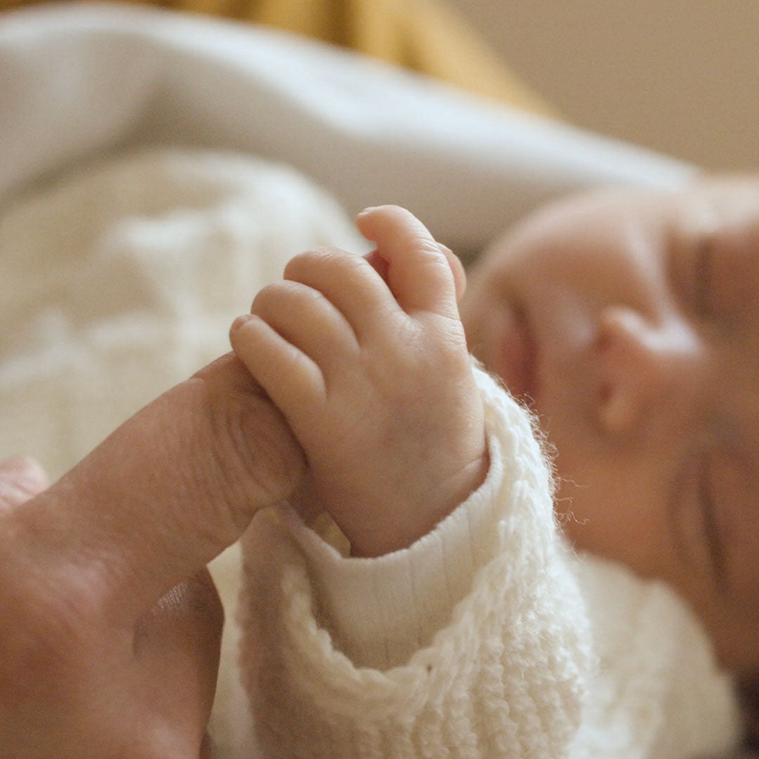 Load video: Newborn baby happily holding mum fingers.
