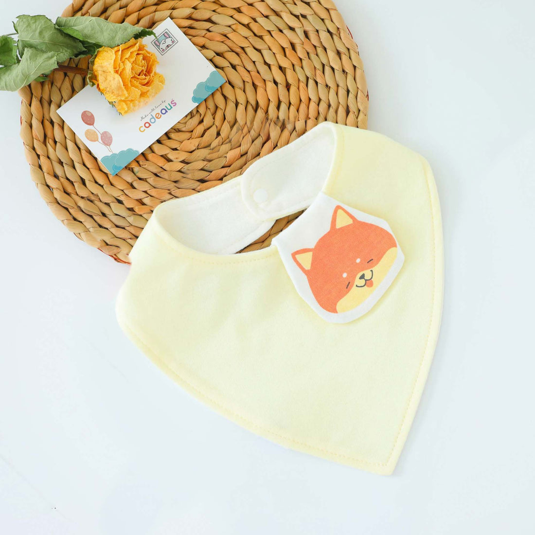 A yellow Shiba design baby bib with Cadeaus gift card