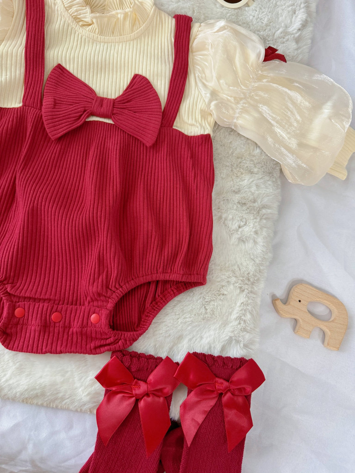 Red Riding Hood baby outfit flat lay – red romper with puff sleeves, bows and red beret