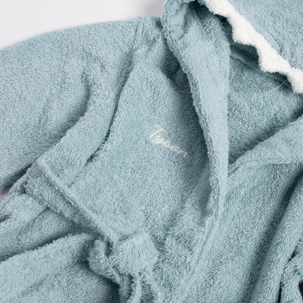 a blue bathrobe with a white embroidered name