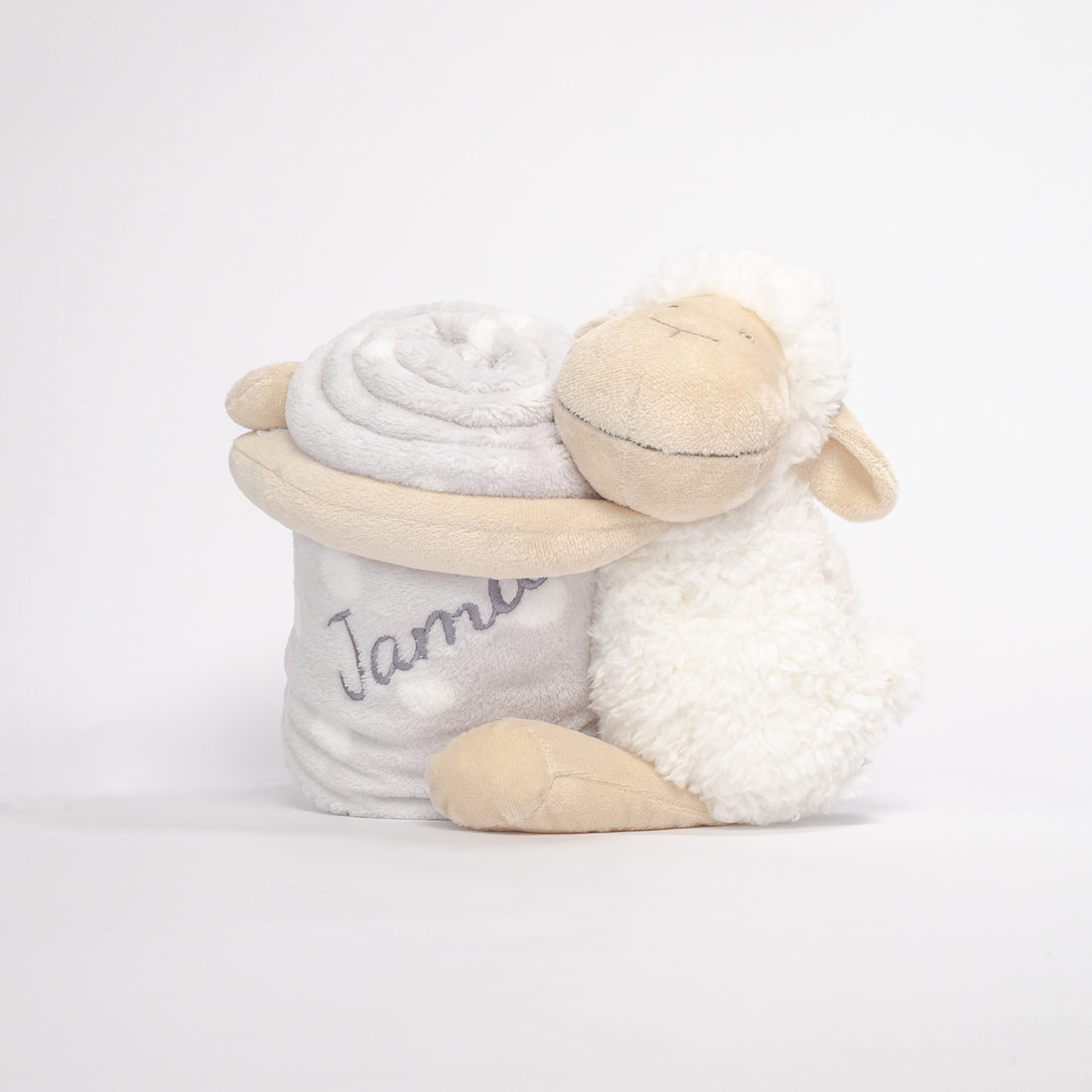Roll-up sheep design blanket with plush sheep hugging the rolled blanket to keep it in place. The blanket features an embroidered baby&