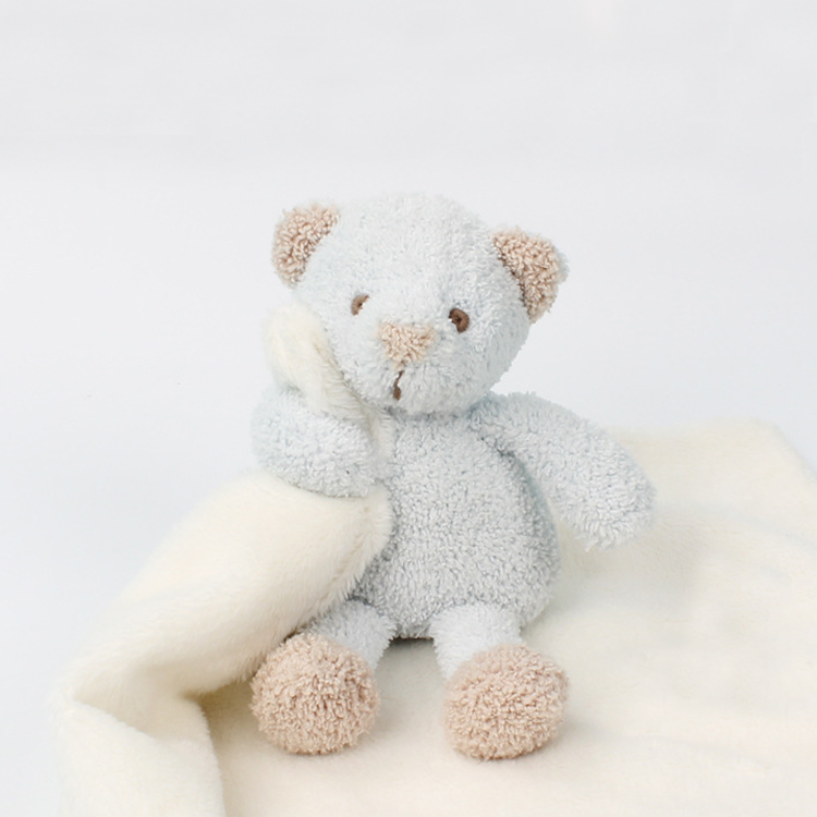 A stuffed animal of a blue bear attached with a white towel.
