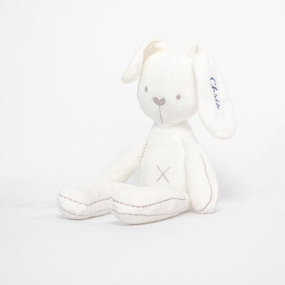 White Bunny Plushie sitting infront of the white background with the name embroidered on the ear.